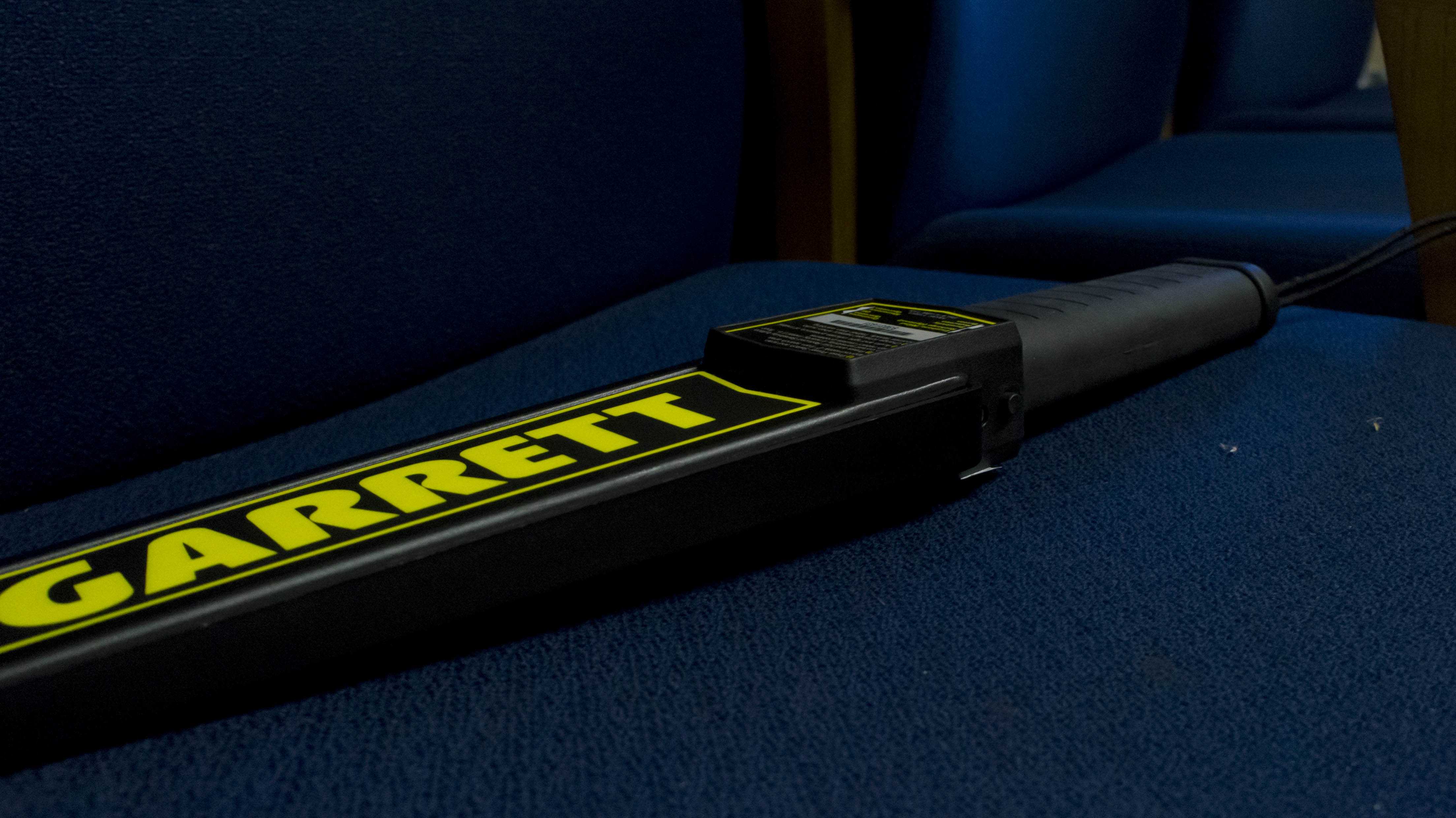 A Garrett metal detection wand resting on a chair in an associate principal's office.