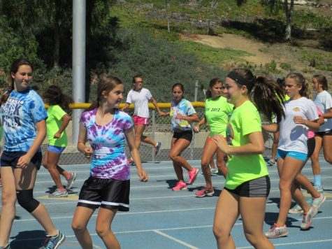 Girls from Cam High's track team perform warm-ups Thursday. Cam High's track team will begin competing in the Coastal Canyon league from now on.