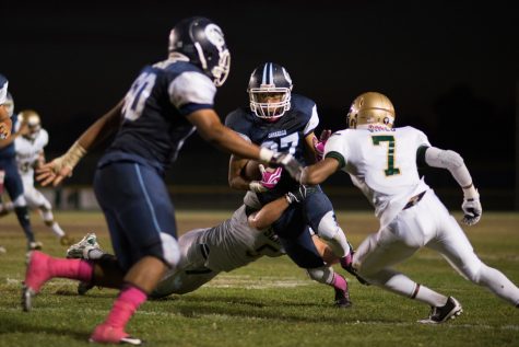 Cam High football player tries to make it past Saint Bonnie's defensive line.