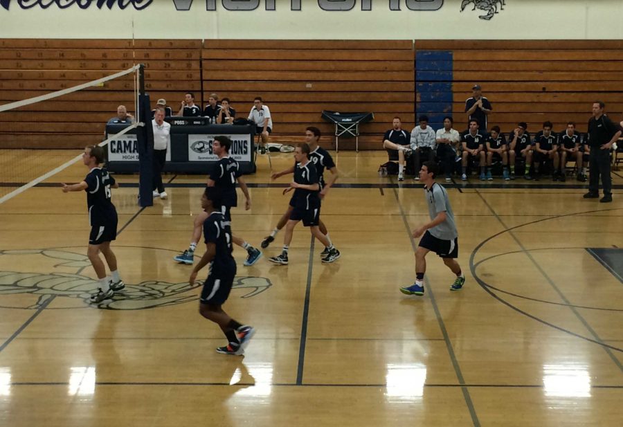 Boys varsity volleyball gathers around the court as they wait for Pacifica High School to serve