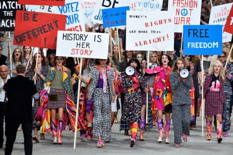 Chanel models walk the catwalk in a finale featuring empowering signs and megaphones.