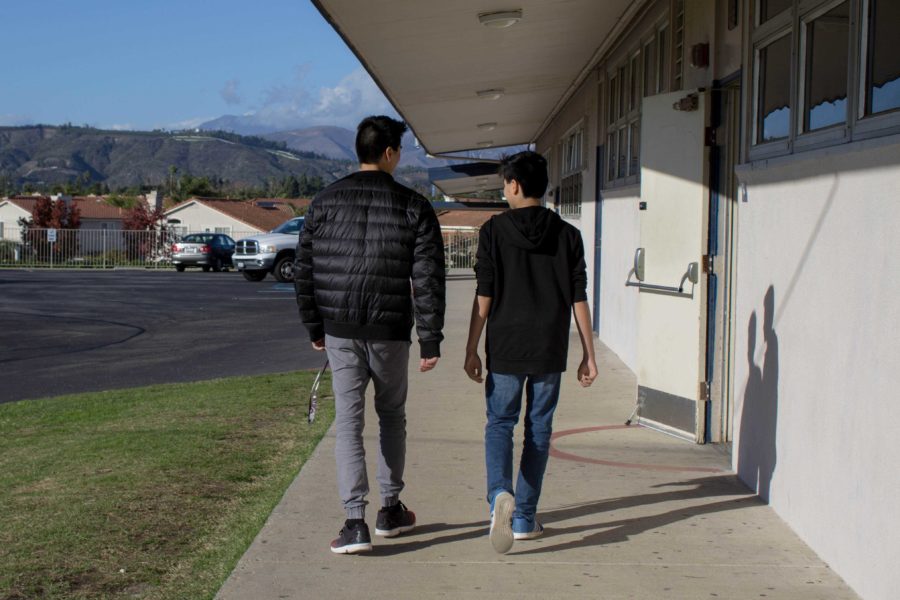 Brothers Adam Fujii, freshman, and Brandon Fujii, senior, walk pass the C-building while Brandon shares some high school advice.