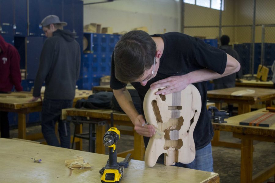 Caiden Thompson, senior, sanding his wooden guitar in his sixth period woodshop class.
