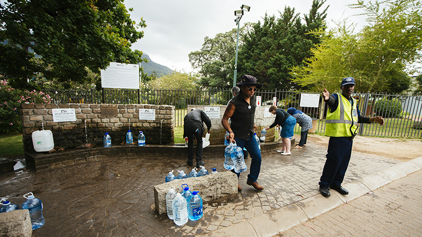 A security officer directs residents as they fill water bottles and containers. Courtesy of Maclean.ca.